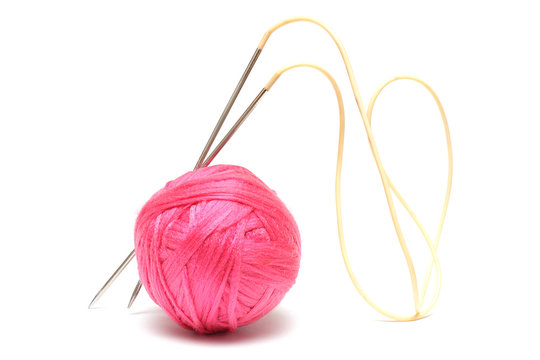 Pink clew with knitting needles isolated on white
