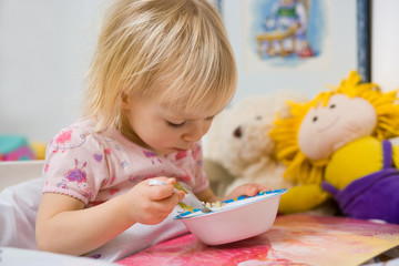 little girl eating in bed