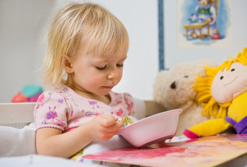 little girl eating in bed