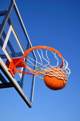 Fototapeta premium Basketball Shot Falling Through the Net, Blue Sky