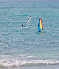Naklejka premium Two Windsurfers Riding the Surf