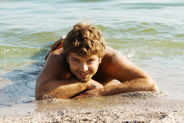 Young man relaxing on a sea shore