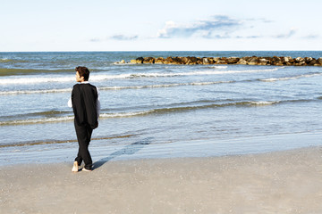Young businessman in contemplation looking at ocean