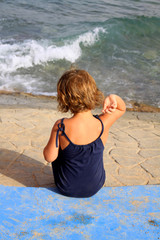 girl sitting on the sea shore - obrazy, fototapety, plakaty