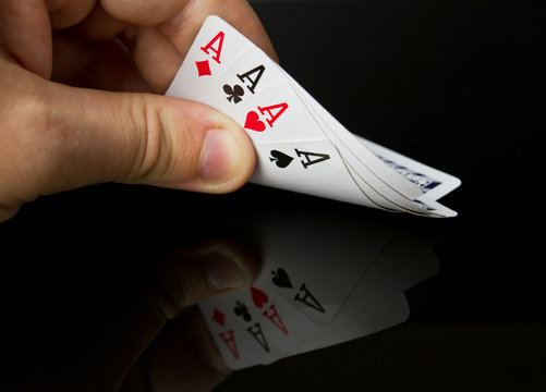 Four aces in the hand with reflection