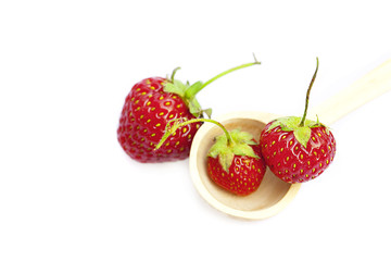 strawberry  in a wooden spoon isolated on white