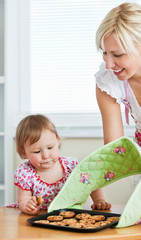 Young girl looking at cookie in kitchen