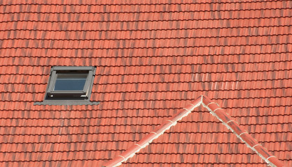 open attic window set into a red tiled roof