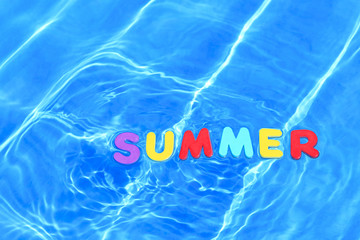 The word summer floating in a swimming pool