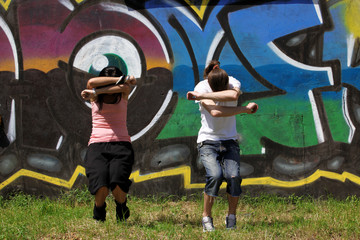 woman modern dancers in sity against graffiti wall