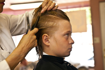 Fototapeta premium young boy at the hairdresser