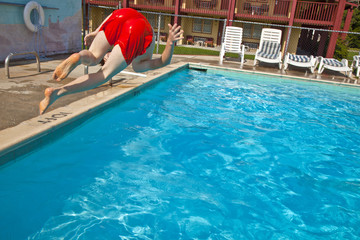 boy is jumping into the pool