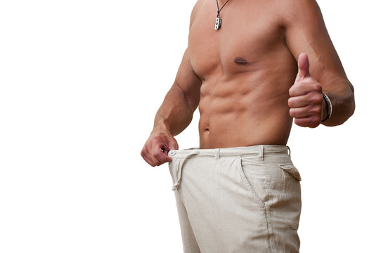 Muscular and tanned male in old pants after weight loss
