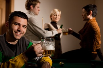 Portrait of man drinking beer at snooker