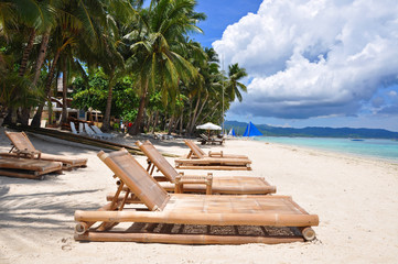 Fototapeta na wymiar Beach chairs on perfect tropical white sand beach in Boracay