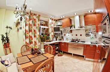 Kitchen interior with wooden furniture, table and many utensils