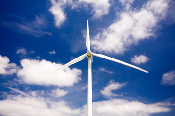 Windmill against a blue sky and clouds, alternative energy sourc