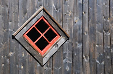 Red window on a dark wooden wall