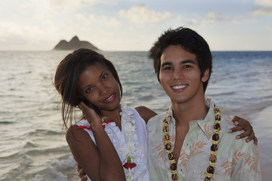 Young Mixed Race Couple At The Beach In Hawaii At Sunrise