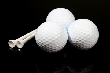 Golf balls and tees on black