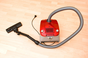 Vacuum cleaner on the wooden floor