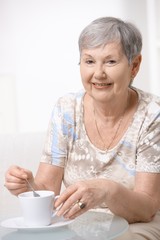 Happy senior woman drinking coffee