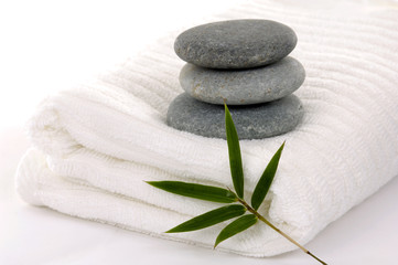 Obraz na płótnie Canvas Zen stones with bamboo leaf on towel