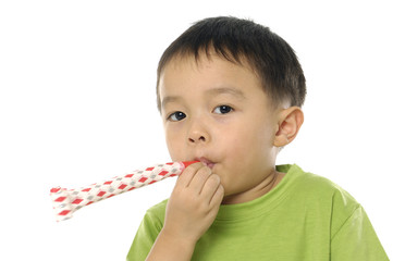 little boy looking at viewer blowing noisemaker