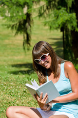 Fototapeta premium Happy young woman with book in park