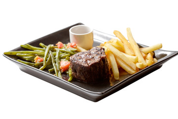 steak and fries on black plate. isolated on a white background