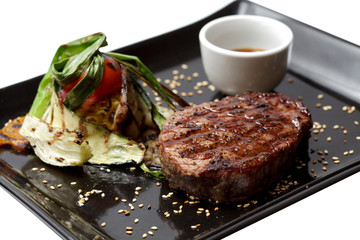 grilled vegetables and meat on black  plate. isolated object