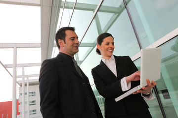 Commerciaux souriant devant ordinateur portable