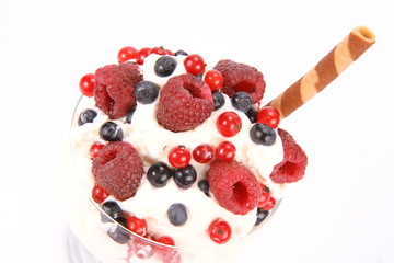 Whipped cream with raspberries, red currants and blue berries