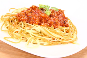 Colorful spaghetti bolognese decorated with basil leaves