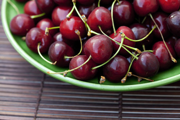 cherry in plate on a bamboo mat