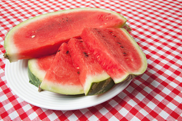 the watermelon on picnic tablecloth
