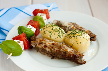 Roasted stuffed pork rolls with potatoes