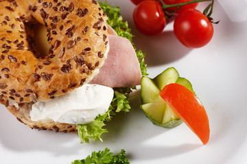 Bagel mit Käseschinkenfüllung und Beilage
