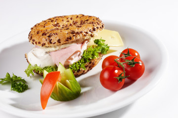 Bagel mit Käseschinkenfüllung und Beilage