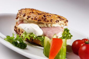Bagel mit Käseschinkenfüllung und Beilage