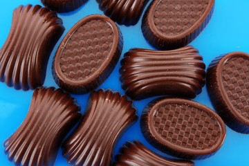Assorted chocolate candies on blue background