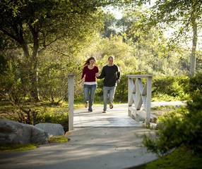 Caucasian couple running on bridge