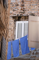 Fototapeta na wymiar Old wall, window and blue linen (Italy)