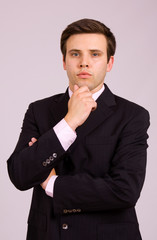 Young business man portrait on a grey background