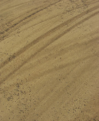 mark from tire on beige curry colored road pavement
