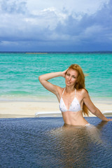 Fototapeta na wymiar Young pretty woman in the pool . Maldives..
