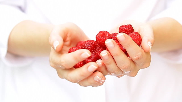Raspberry fruits in women's hands.