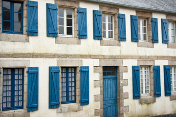 Facade of traditional breton houses with blue shutters in france