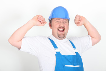 Portrait d'un ouvrier levant les bras sur fond blanc
