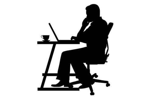 silhouette of a man typing at a laptop